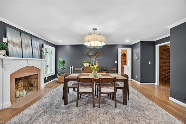 1901 Runnymede Rd, Winston-Salem, NC 27104 - dining room featuring wood finished floors, a chandelier, ornamental molding, a fireplace with flush hearth, and recessed lighting