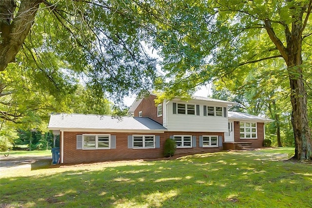 view of front of house featuring a front lawn and brick siding