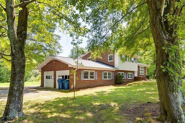 rear view of property with a garage and a yard