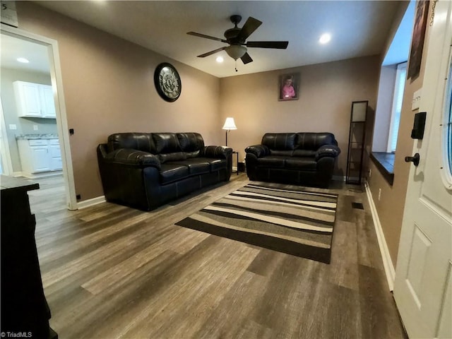 living room with ceiling fan and dark wood-type flooring