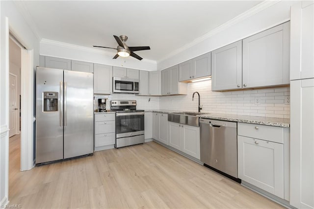 kitchen featuring stainless steel appliances, a sink, and gray cabinetry