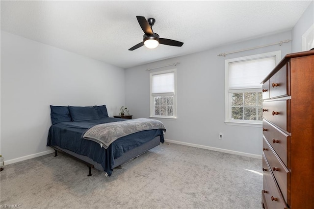 bedroom featuring a textured ceiling, carpet floors, a ceiling fan, and baseboards