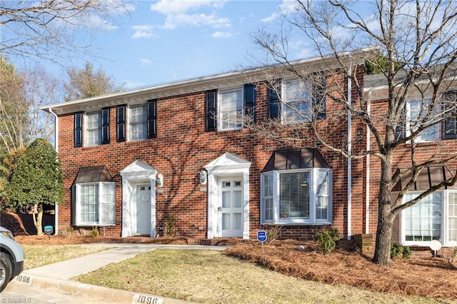 colonial inspired home with brick siding