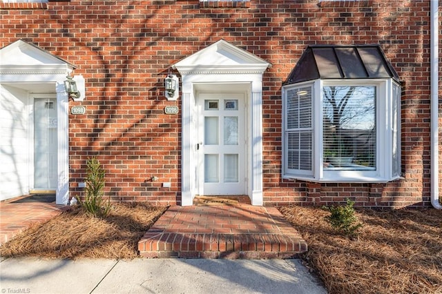 doorway to property featuring brick siding