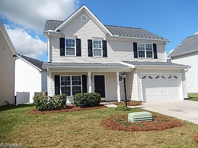 6125 Birkdale Dr, High Point, NC 27265 - traditional home featuring driveway, a garage, a front yard, covered porch, and roof with shingles