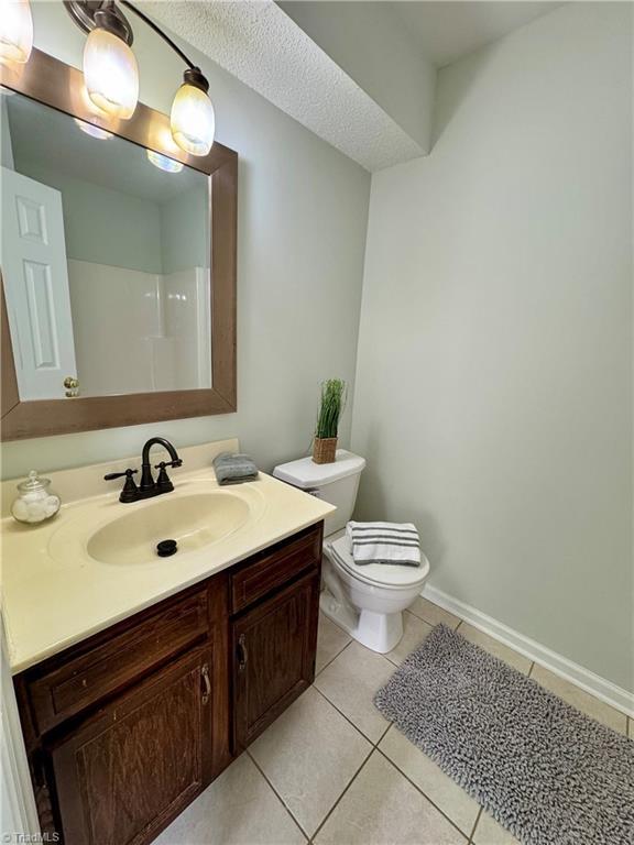 733 Rivertree Ln, Winston-Salem, NC 27103 - full bath with toilet, tile patterned floors, vanity, baseboards, and a shower