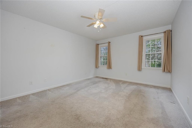 carpeted empty room with a textured ceiling and ceiling fan