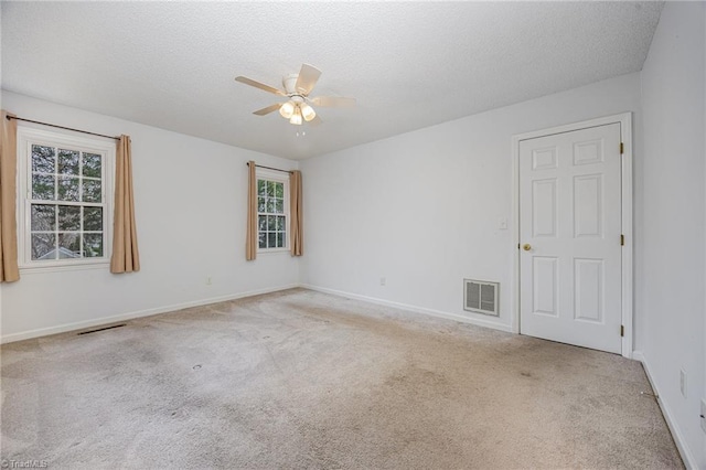 carpeted empty room with ceiling fan and a textured ceiling