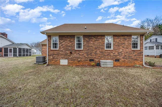 rear view of property with a sunroom, a yard, and central air condition unit