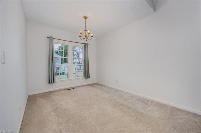 carpeted spare room with an inviting chandelier