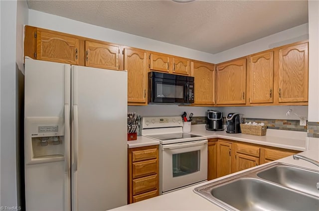 kitchen with sink, white appliances, and a textured ceiling