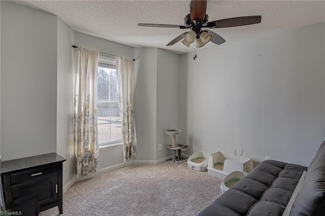 sitting room with ceiling fan, light carpet, and a textured ceiling