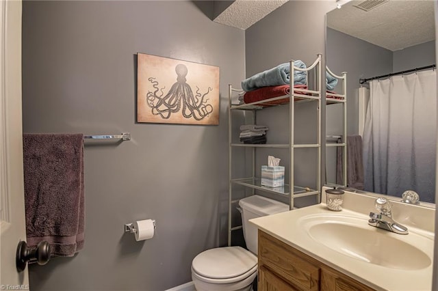 bathroom with vanity, a textured ceiling, and toilet