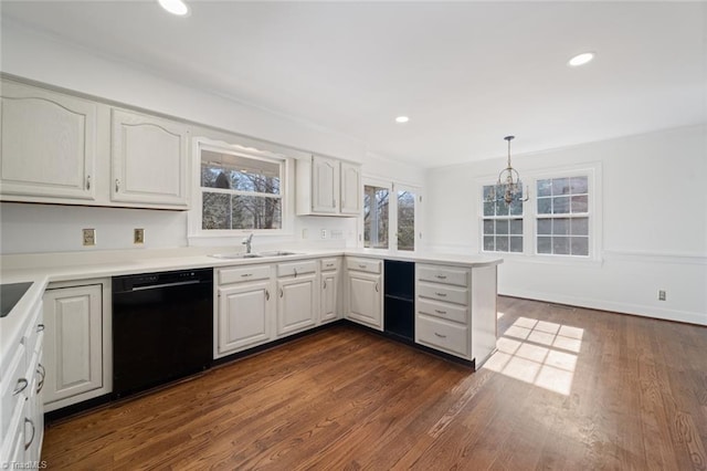 kitchen featuring dishwasher, sink, white cabinets, and decorative light fixtures