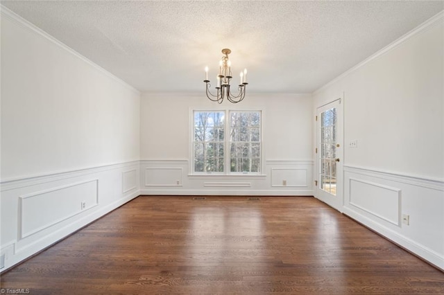 unfurnished dining area with ornamental molding, dark hardwood / wood-style flooring, a textured ceiling, and a notable chandelier