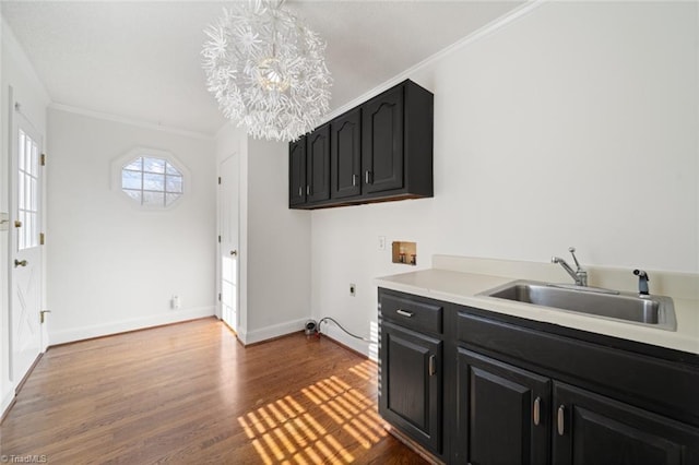 kitchen featuring an inviting chandelier, ornamental molding, sink, and hardwood / wood-style floors