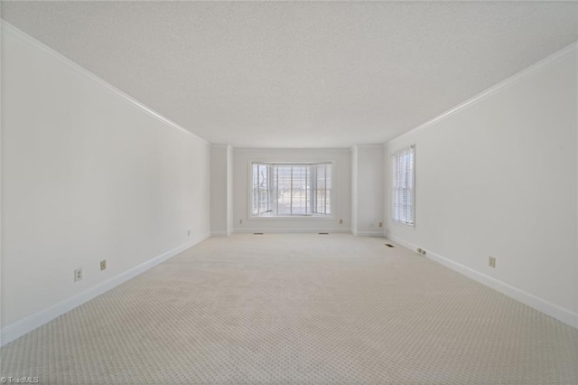 carpeted empty room with ornamental molding and a textured ceiling