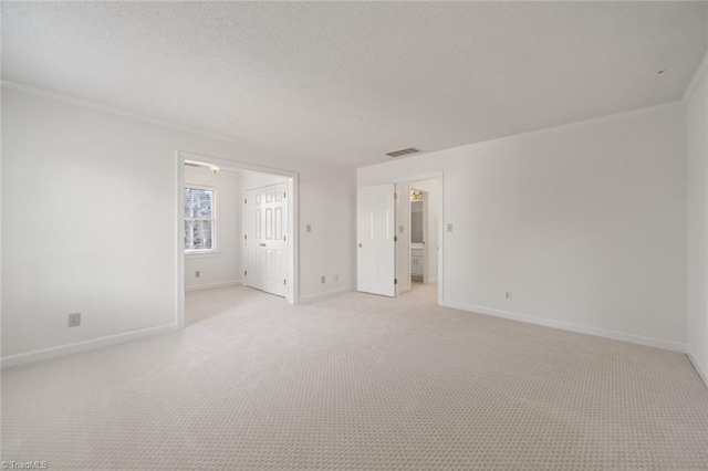 unfurnished room featuring light colored carpet and a textured ceiling