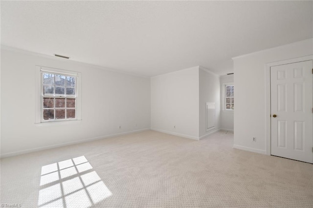 empty room with crown molding and light carpet