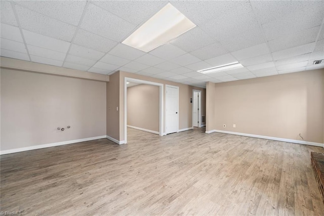 basement featuring wood-type flooring and a paneled ceiling