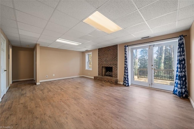 unfurnished living room featuring a paneled ceiling, wood-type flooring, and a fireplace