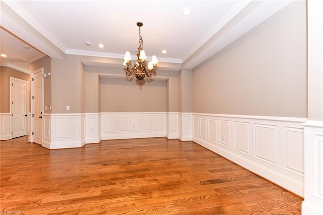 unfurnished room featuring ornamental molding, wood-type flooring, and a notable chandelier