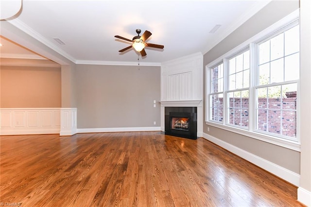 unfurnished living room featuring ceiling fan, hardwood / wood-style floors, and ornamental molding