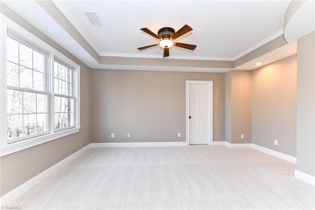 carpeted spare room with crown molding, ceiling fan, and a tray ceiling