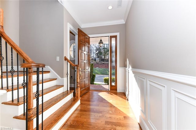 entrance foyer featuring ornamental molding and hardwood / wood-style flooring