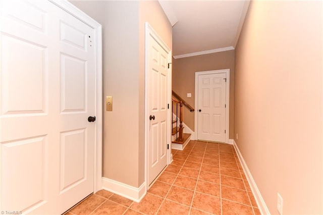 hall featuring light tile patterned floors and crown molding