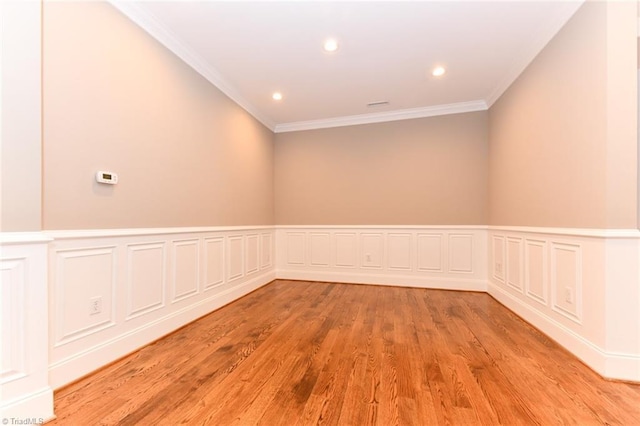 empty room featuring light hardwood / wood-style flooring and crown molding