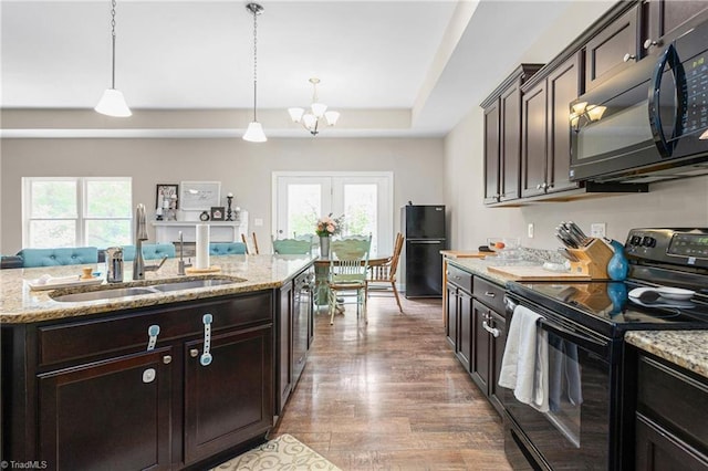 kitchen with plenty of natural light, a sink, a chandelier, and black appliances
