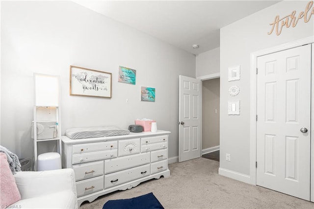 bedroom with baseboards and light carpet
