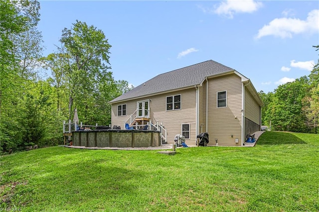 back of property featuring a lawn, an outdoor pool, and stairway