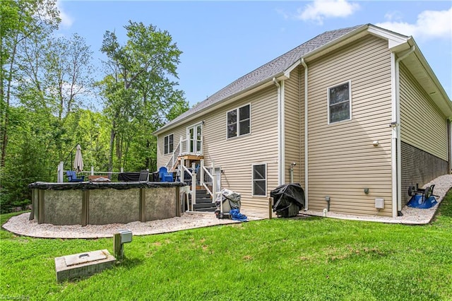 back of house featuring a lawn and a covered pool