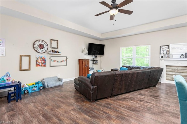 living room featuring baseboards, a ceiling fan, and wood finished floors