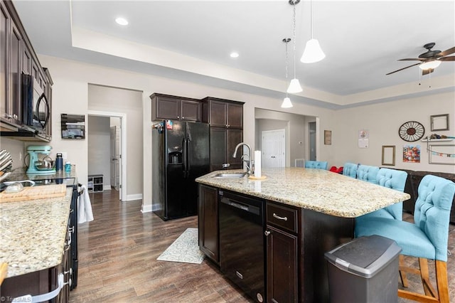 kitchen featuring a sink, a raised ceiling, black appliances, and open floor plan