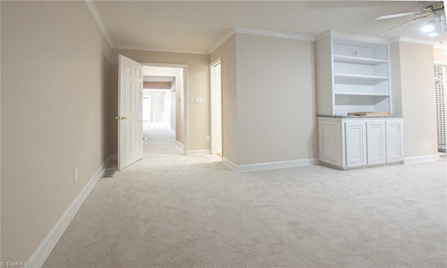 interior space featuring a textured ceiling, light colored carpet, built in features, and crown molding