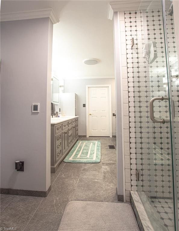 bathroom with vanity, a shower with door, and crown molding