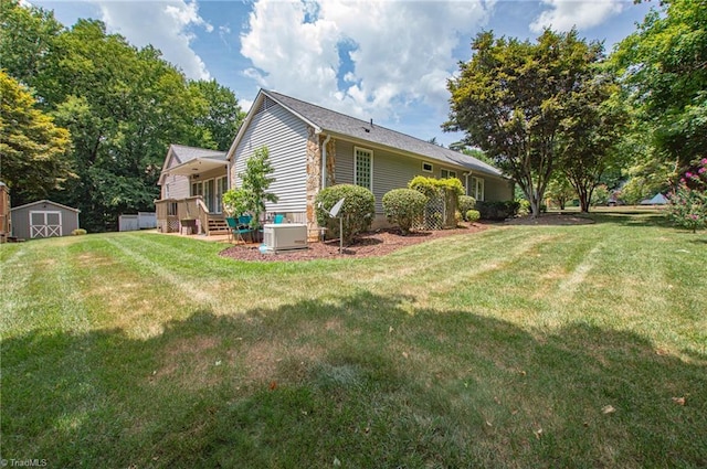 view of side of home with a lawn and a storage unit