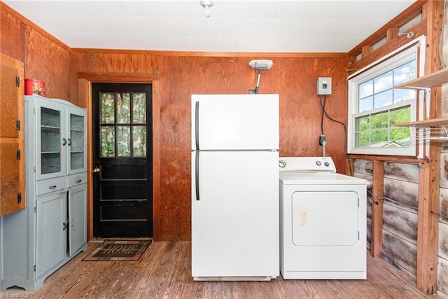 washroom with washer / dryer, wood finished floors, and wood walls