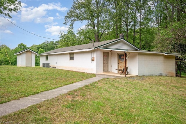 ranch-style house with a front lawn, cooling unit, and concrete block siding