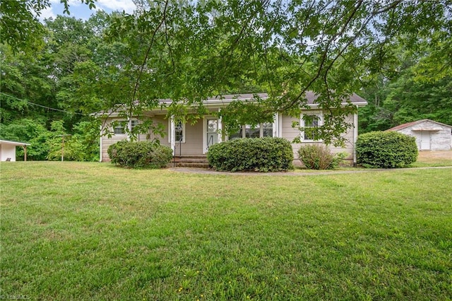 view of property hidden behind natural elements featuring a front lawn and covered porch