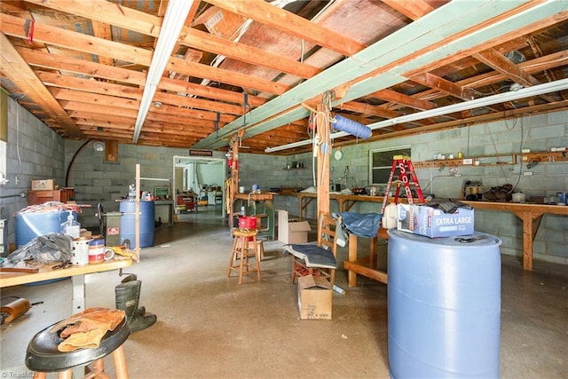 unfinished below grade area with a workshop area and concrete block wall