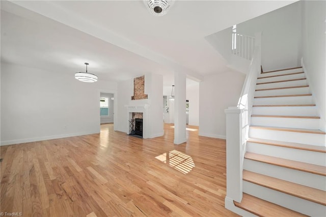 unfurnished living room with a fireplace and light hardwood / wood-style flooring