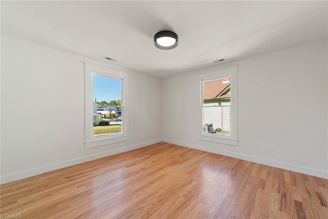 unfurnished room featuring plenty of natural light and light hardwood / wood-style floors