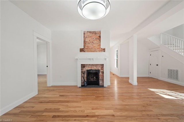 unfurnished living room featuring a fireplace and light wood-type flooring