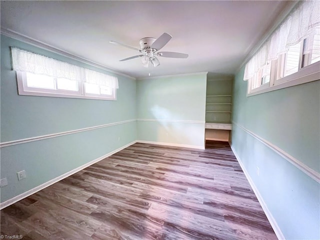 unfurnished room featuring hardwood / wood-style floors, a wealth of natural light, crown molding, and ceiling fan