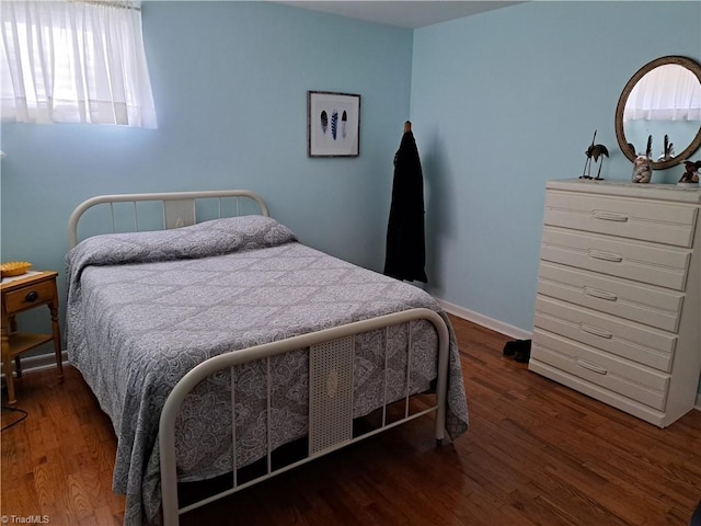 bedroom with dark hardwood / wood-style flooring