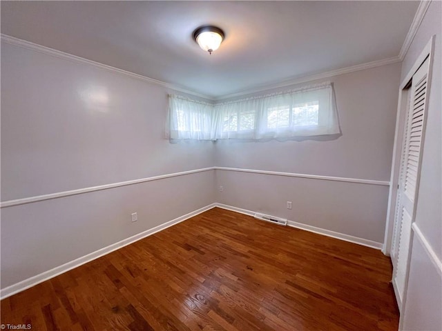 unfurnished bedroom featuring dark hardwood / wood-style floors, a closet, and crown molding